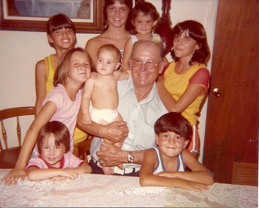 Henry George Starr and Grandkids around his kitchen table, ca. 1977. From lower left to bottom right: Kirby Brown II, Rhonda McClendon, Shanna Cahill, Andrea Gee, Amber Denning, Ronda Rutledge, Chuck Denning, Kelly Starr (being held). Courtesy Sharon Starr Sneed. 