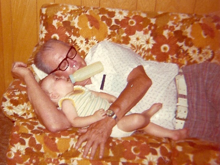 A person feeding a baby  Description automatically generated