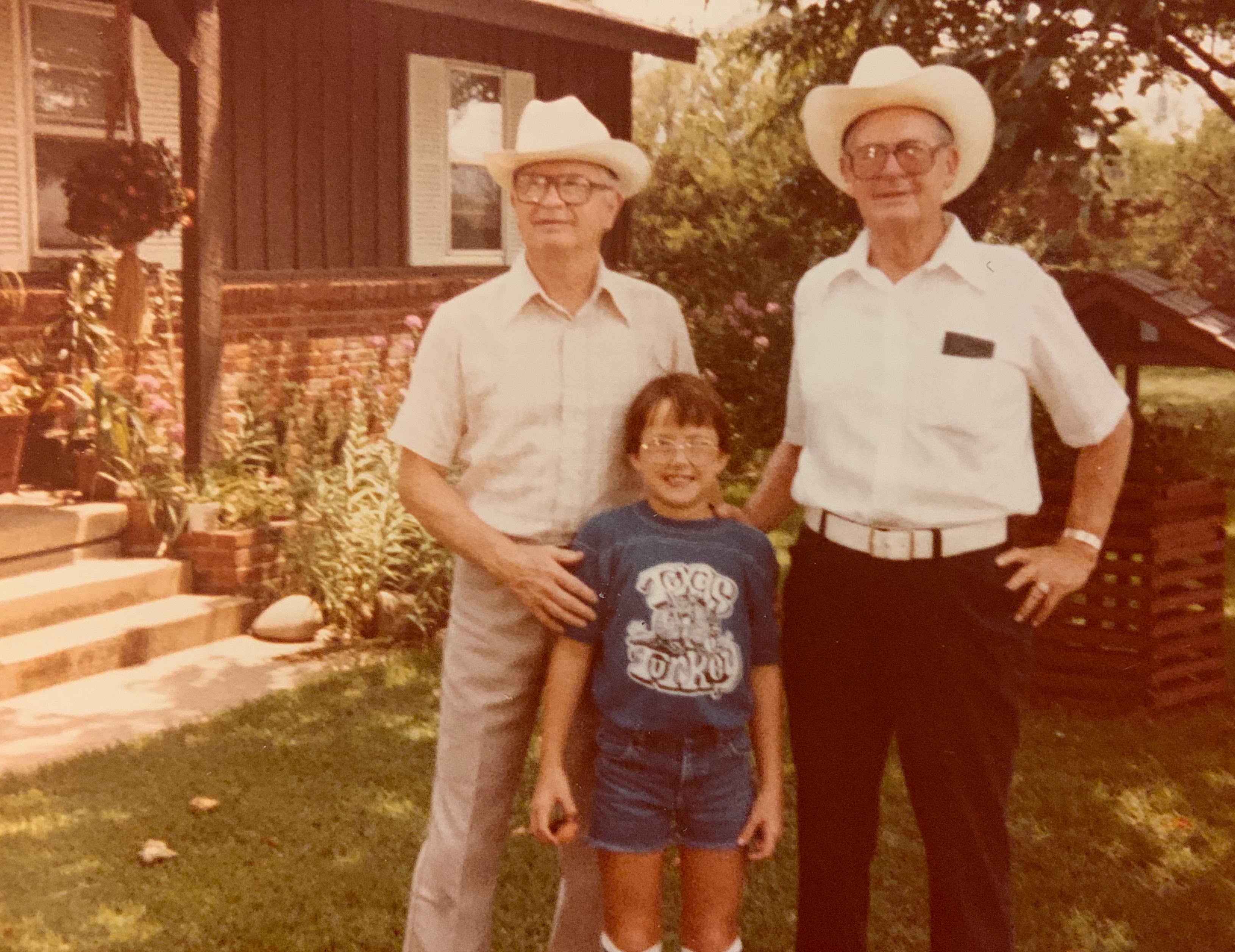 A group of men standing in front of a house  Description automatically generated