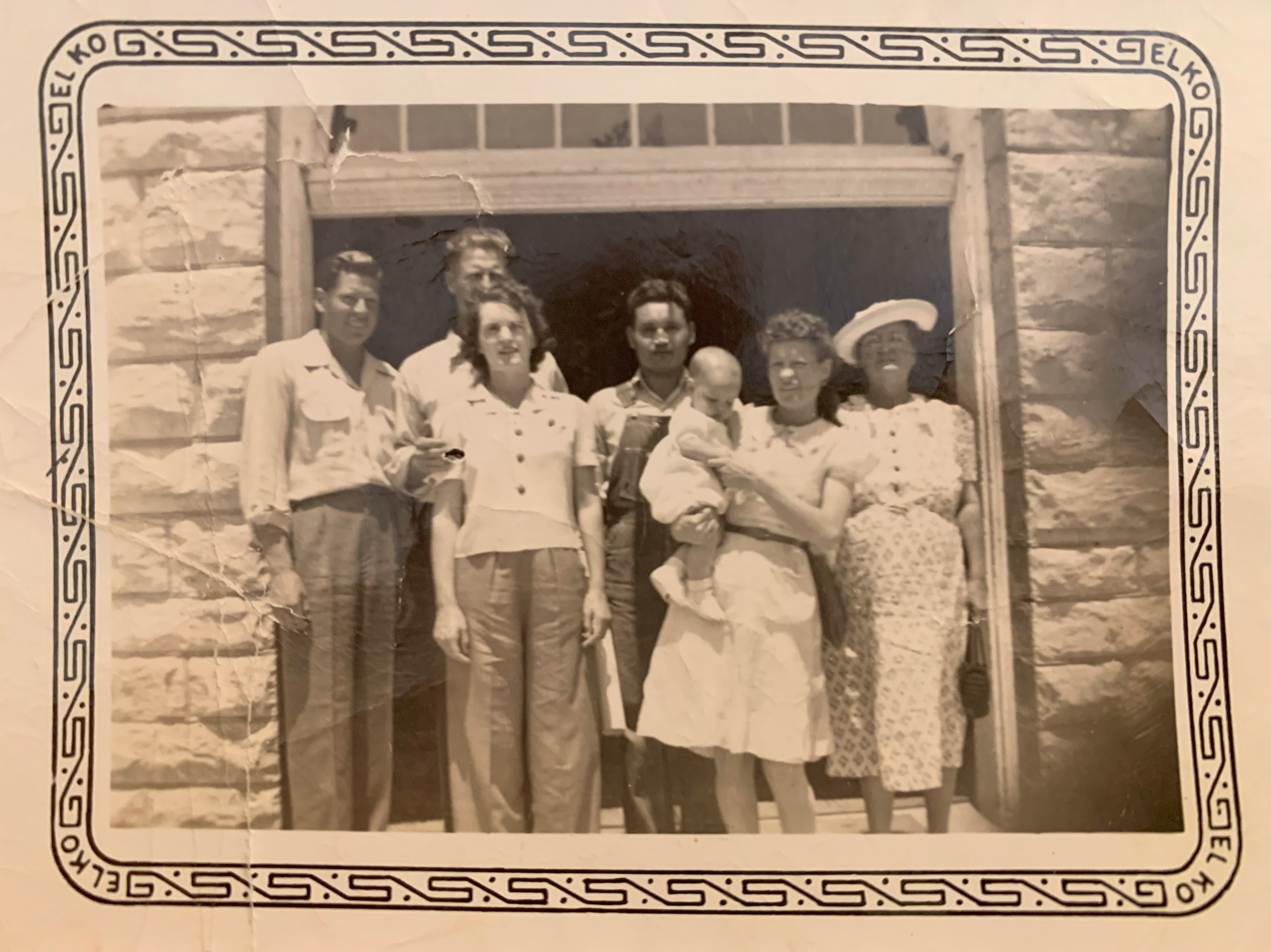 A group of people standing in front of a building  Description automatically generated