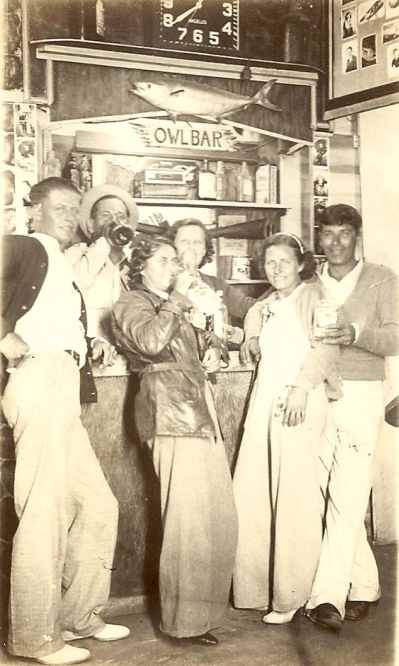 A group of people standing in a bar  Description automatically generated