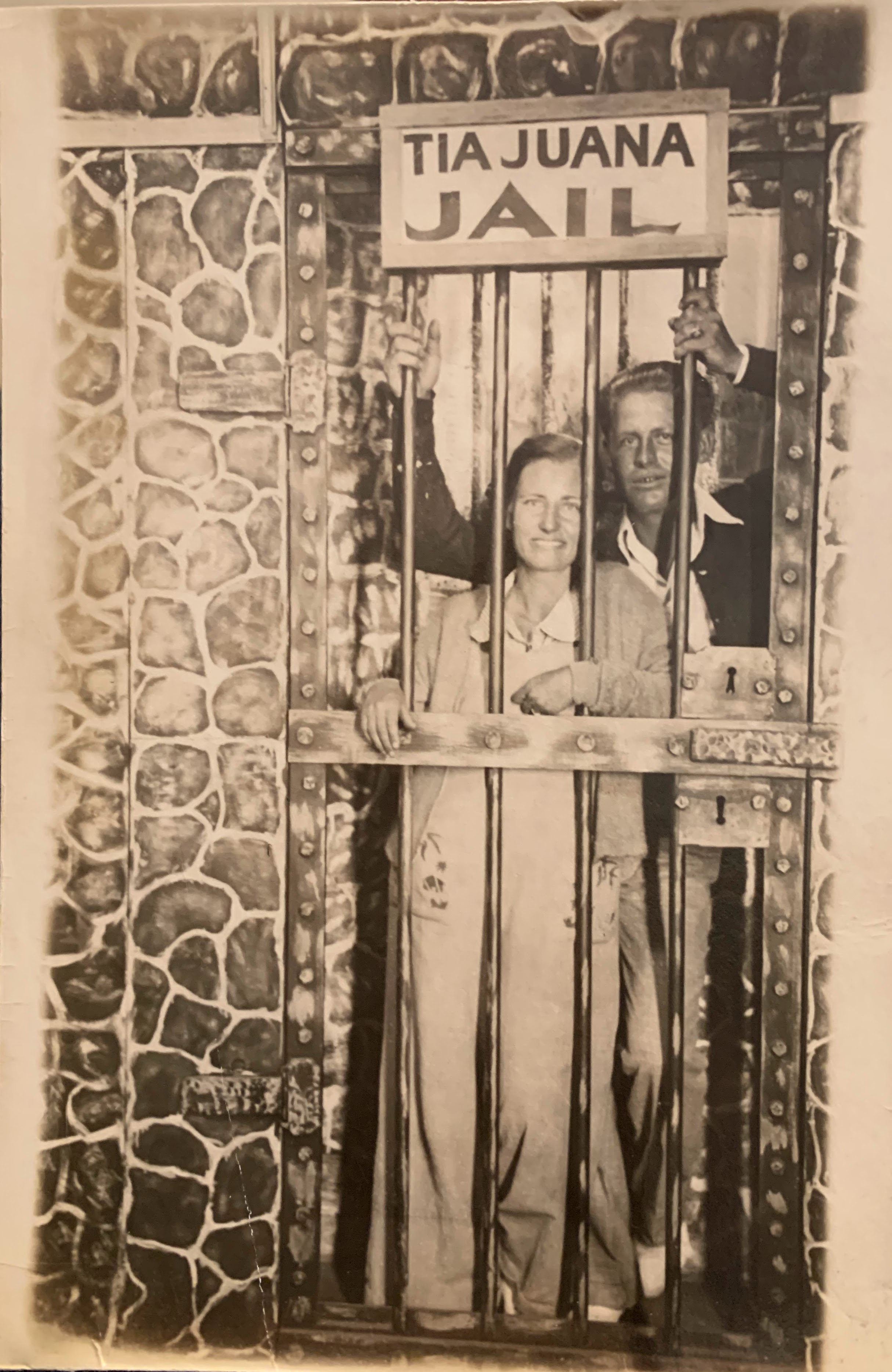 A person and person standing behind bars  Description automatically generated